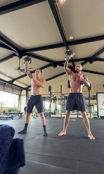Two athletes training with kettlebells
